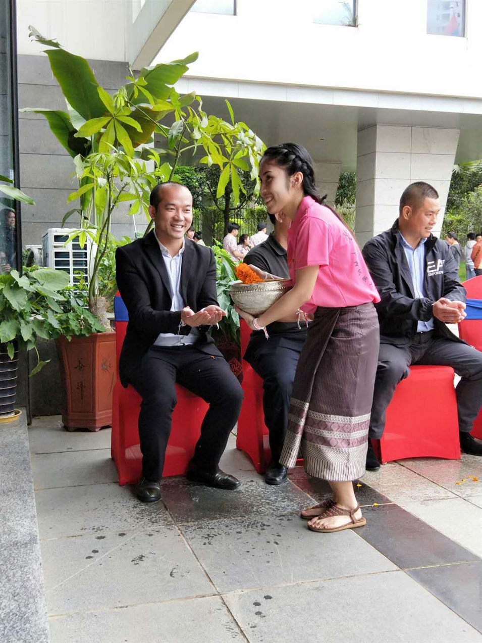 老撾駐廣西留學(xué)生代表將浸有花瓣的香水灑客人的手上，表示對嘉賓的美好祝福（圖一）