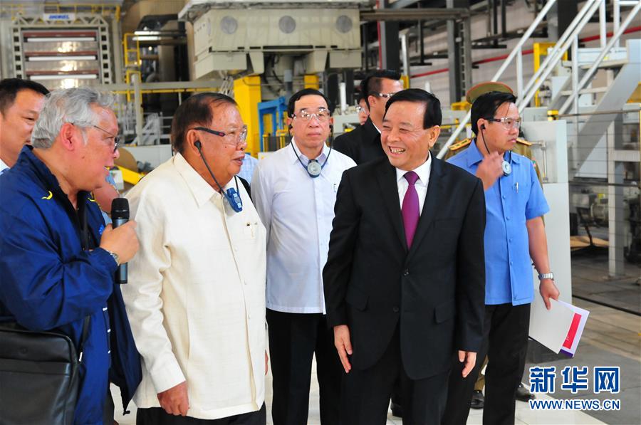 3月10日，在老撾沙灣拿吉省車(chē)邦縣，老撾人民革命黨中央總書(shū)記、國家主席本揚（左二）在山東太陽(yáng)紙業(yè)股份有限公司董事長(cháng)李洪信（右二）的陪同下視察公司。 新華社記者章建華攝